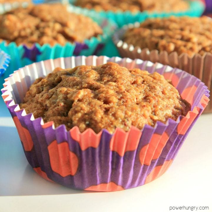 close-up of a vegan buckwheat carrot muffin with more muffins in the background