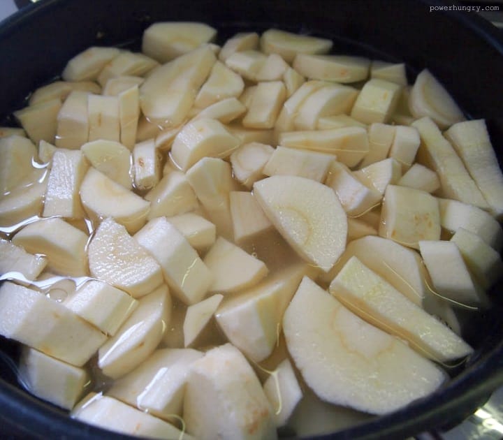 cut parsnips cooking in a saucepan of water