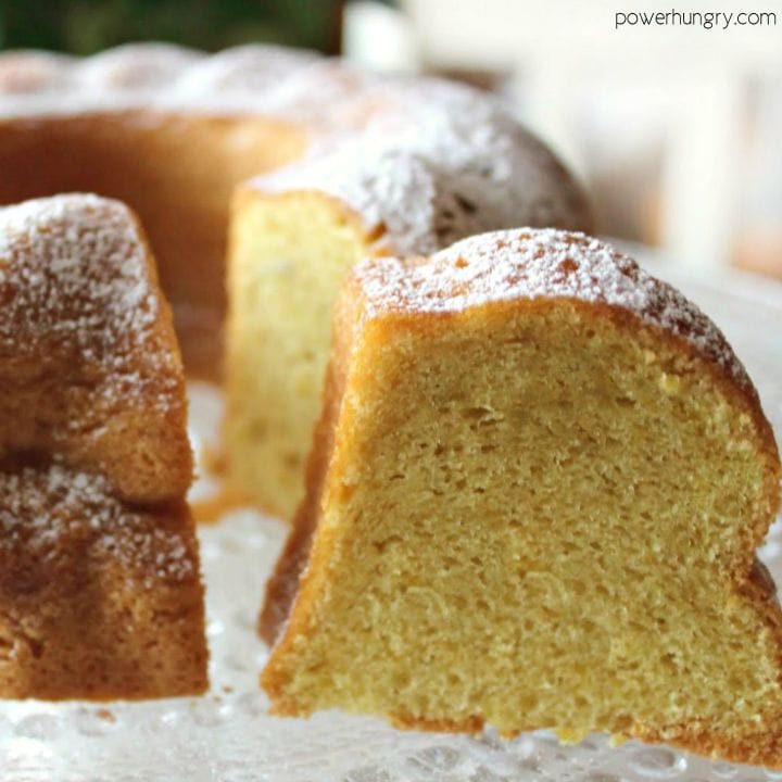 Vanilla Bundt cake on a platter, sliced, and sprinkled with confectioners' sugar