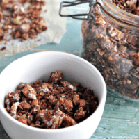 oil-free chocolate granola in a white bowl with more granola in background