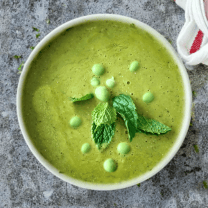 ovehead shot of green soup made with split pes and frozen green peas in a white bowl