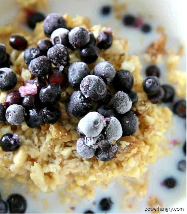 close-up of brown rice porridge topped with some chopped walnuts and blueberries