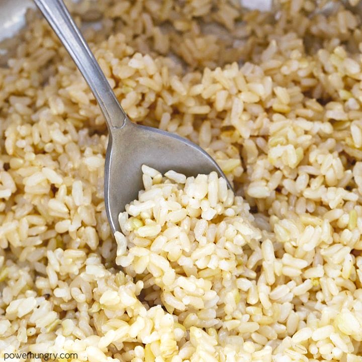 close-up of a spoonful of cooked brown rice in a saucepan