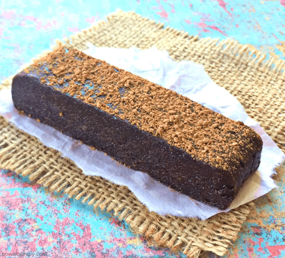 a single chocolate black bean protein bar on a piece of parchment paper