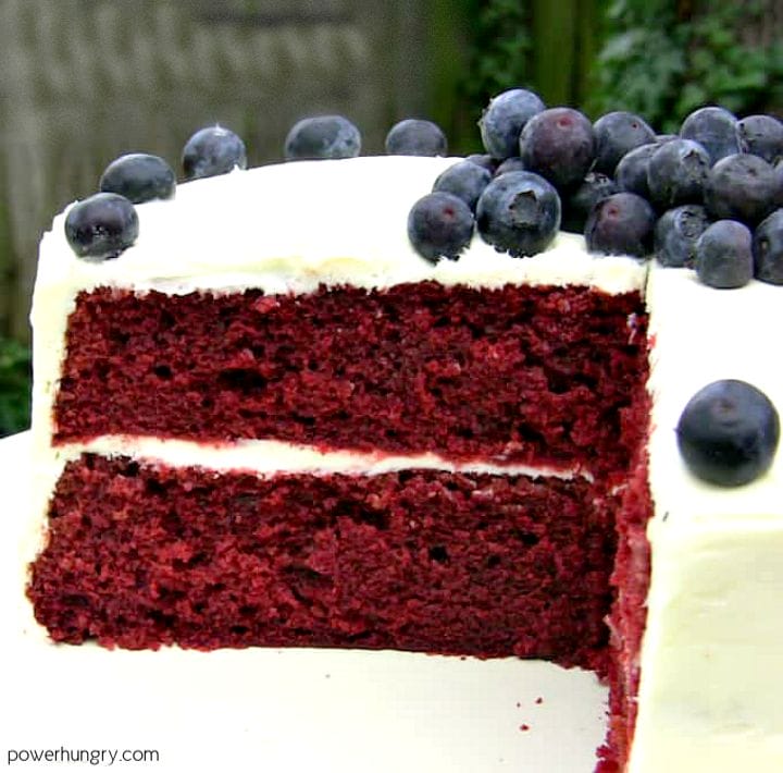 layered vegan gf red velvet cake on a white pedestal