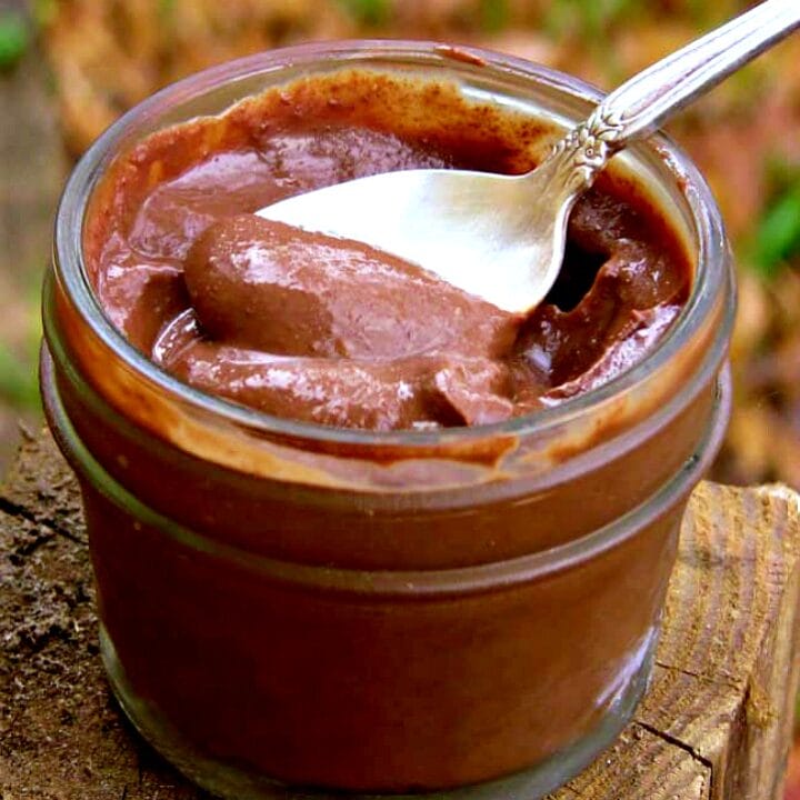 small jar full of healthy chocolate pumpkin pudding with a spoon