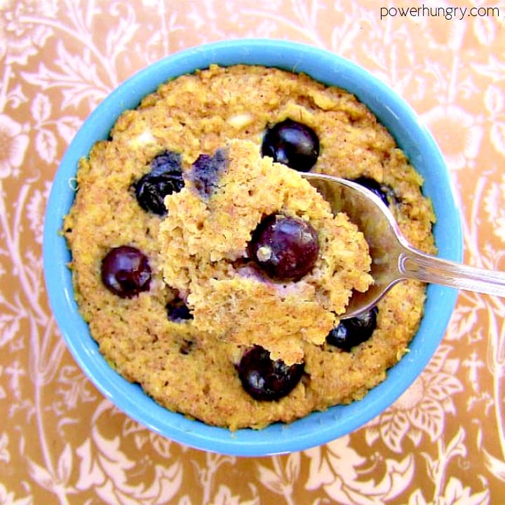 overhead shot of a vegan blueberry oat mug muffin with a spoon