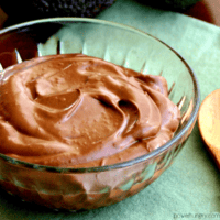 healthy chocolate avocado pudding in a glass bowl atop a green napkin