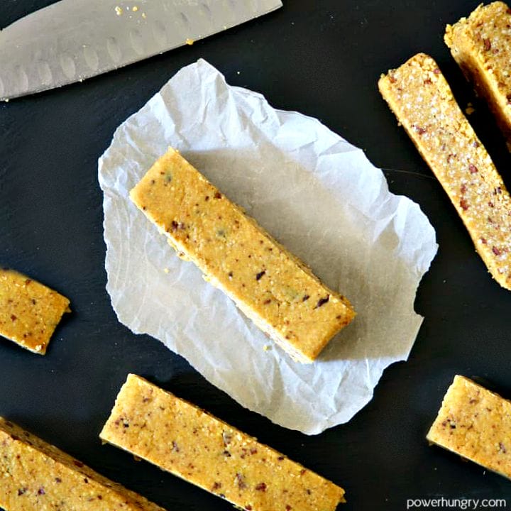 multiple millet and apricot energy bars on a slate background