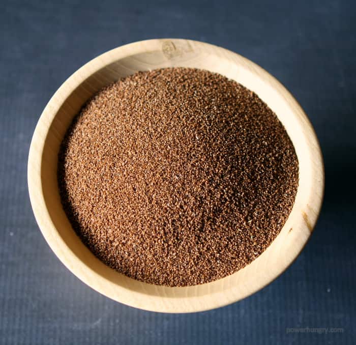 whole grain, uncooked teff grains in a wooden bowl