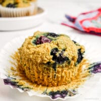 a coconut flour blueberry muffin with the muffin paper peeled back
