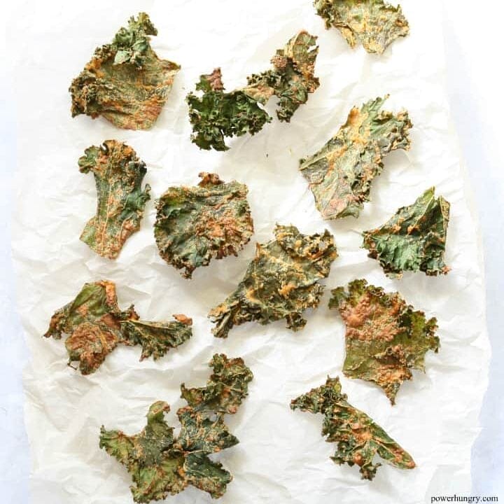 overhed shot of kale chips on white parchment paper