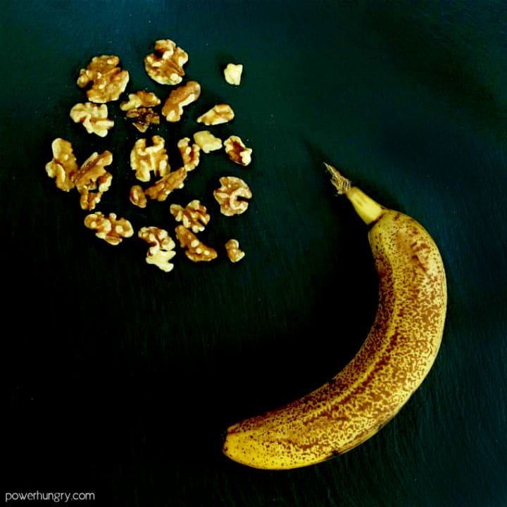 an overripe banana and toasted walnuts on a piece of slate