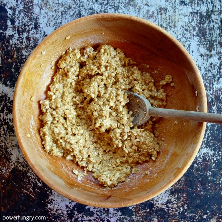 Wooden mixing bowl and spoon with the combined ingredients for oat protein cookies.