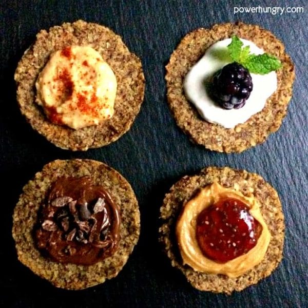 overhead shot of 4 gluten-free vegan breads with toppings on a piece of slate