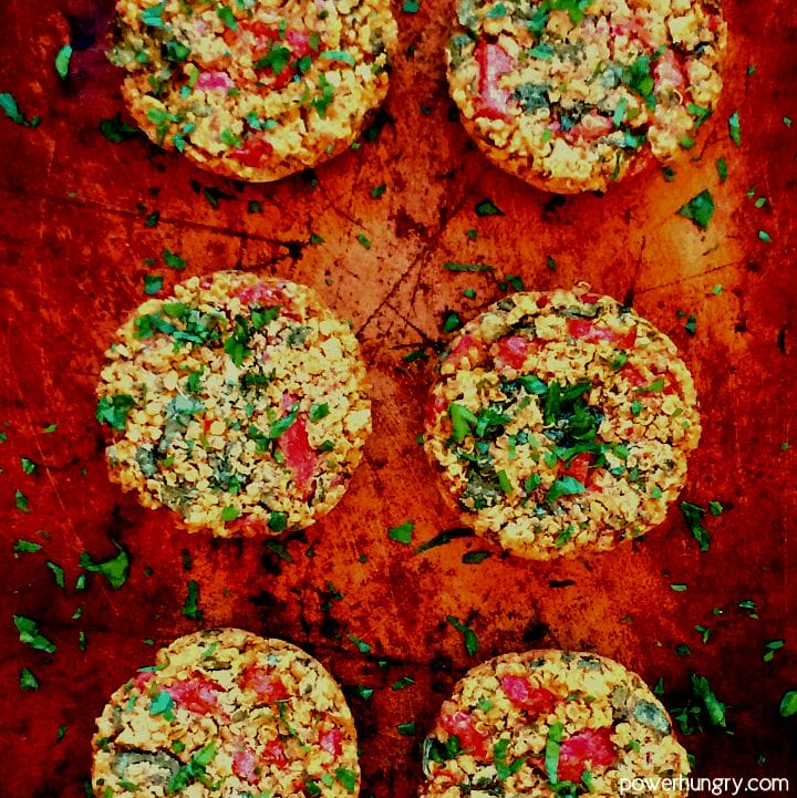 overhead shot of vegan quinoa muffin tin burgers on an aged baking sheet