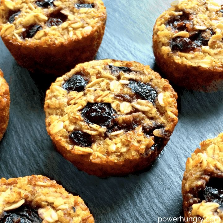 A batch of healthy blueberry quinoa oat muffins on a slate cutting board