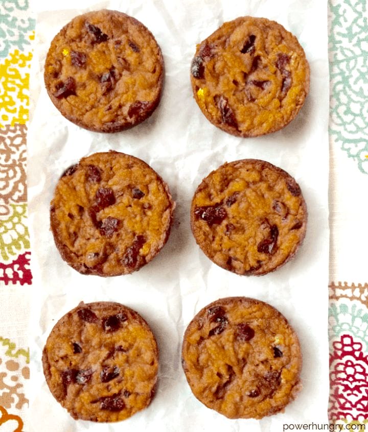 overhead shot of pumpkin cranberry blondies on white parchment paper, on top of a colorful napkin