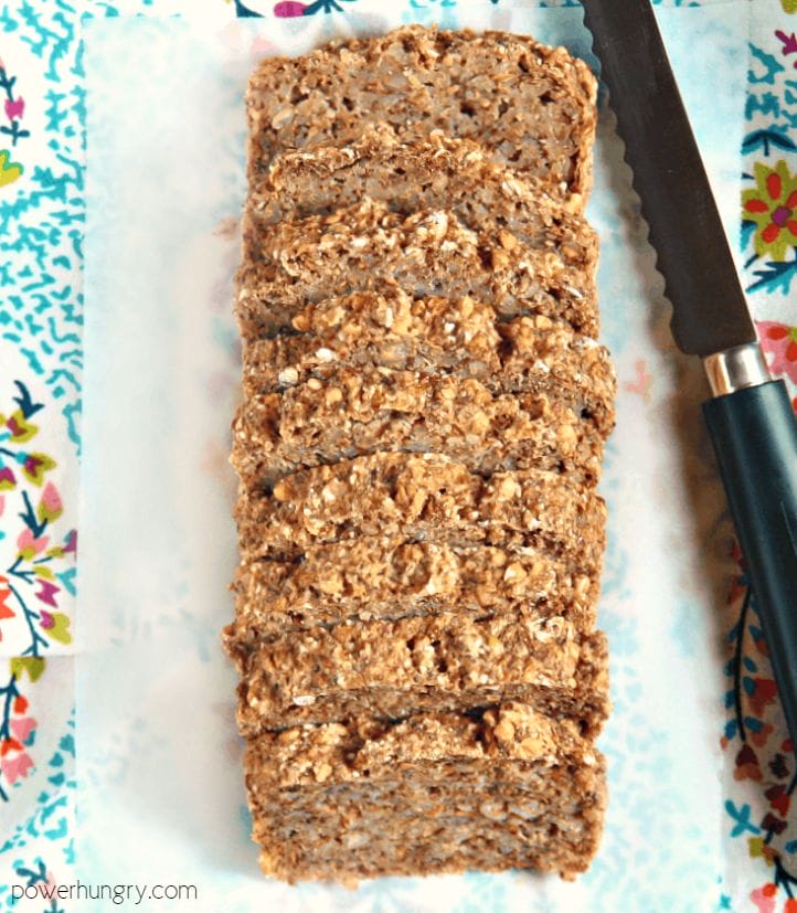 overhead view of buckwheat chia flax bread on a piece of parchment paper, a cutting knife alongside