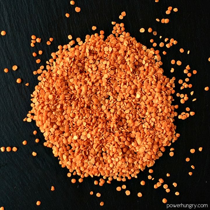 a pile of red lentils on a piece of slate