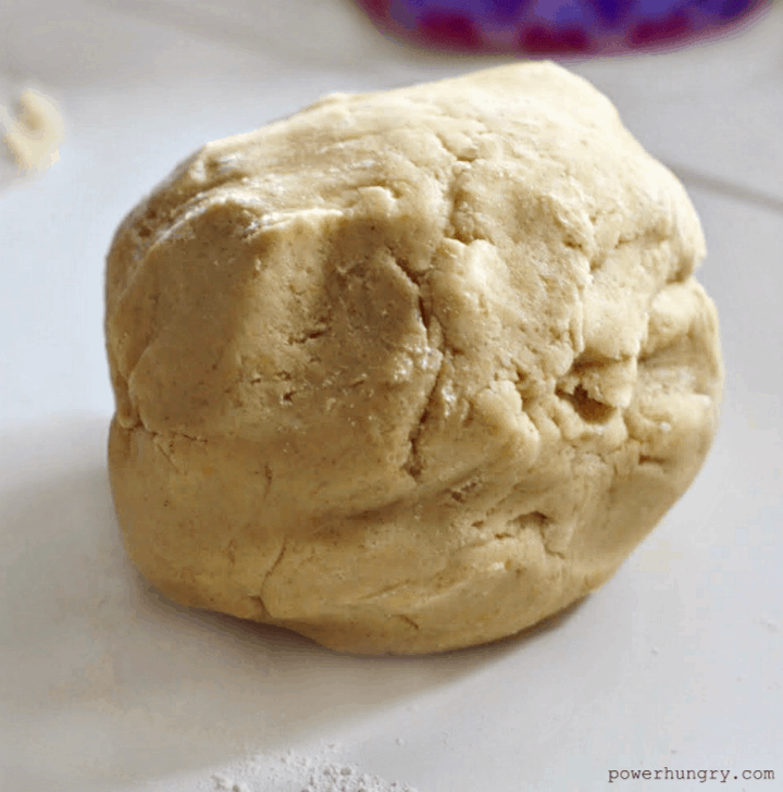 a ball of coconut flour cookie dough on a cutting board