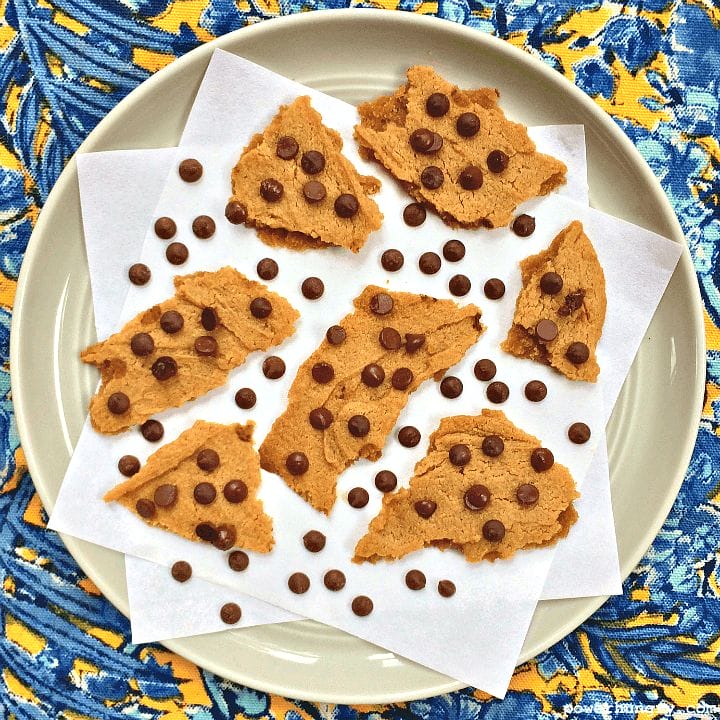 pieces of vegan chocolate chip cookie brittle on a grey plate