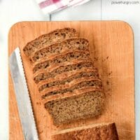 mini loaf of walnut oat blender bread, sliced, on a wooden cutting board