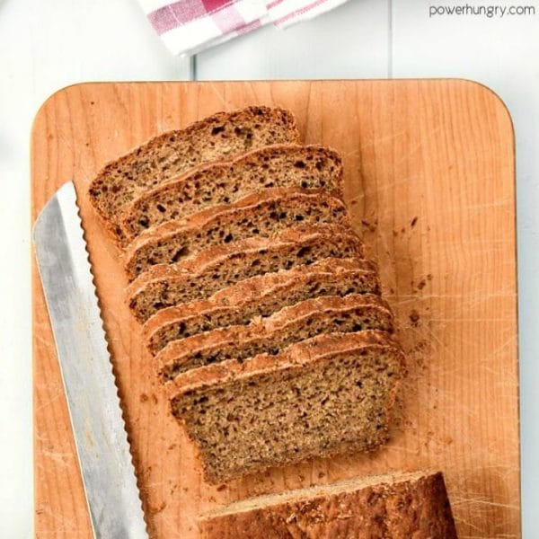 mini loaf of walnut oat blender bread, sliced, on a wooden cutting board