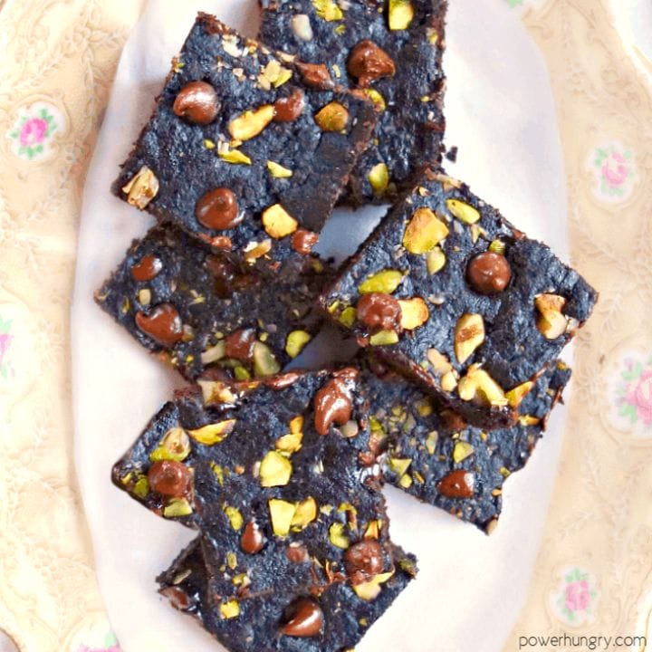 vegan tiger nut flour brownies, studded with chocolate chips and nuts, on a china plate