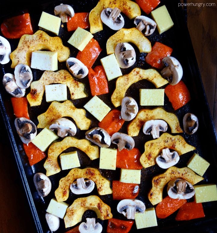 uncooked acorn squash mushrooms, peppers and Burmese tofu on a sheet pan
