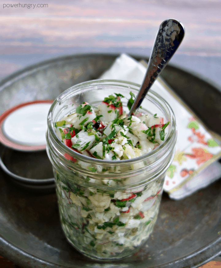 radish cauliflower salad in a jar with a fork inserted