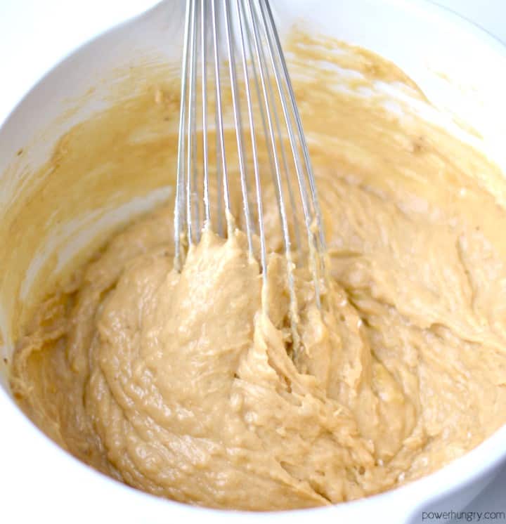 batter for chickpea flour muffins in a mixing bowl with a whisk