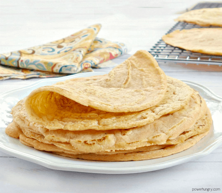 a stack of red lentil tortillas on a white plate