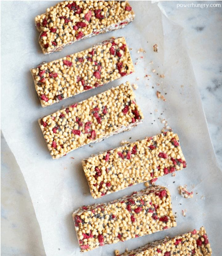strawberry puffed millet energy bars laid out on a piece of white parchment paper on top top of a slab of marble