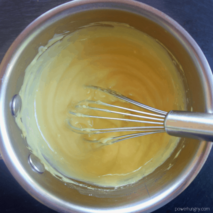 chickpea flour batter in a silver saucepan with a whisk inserted