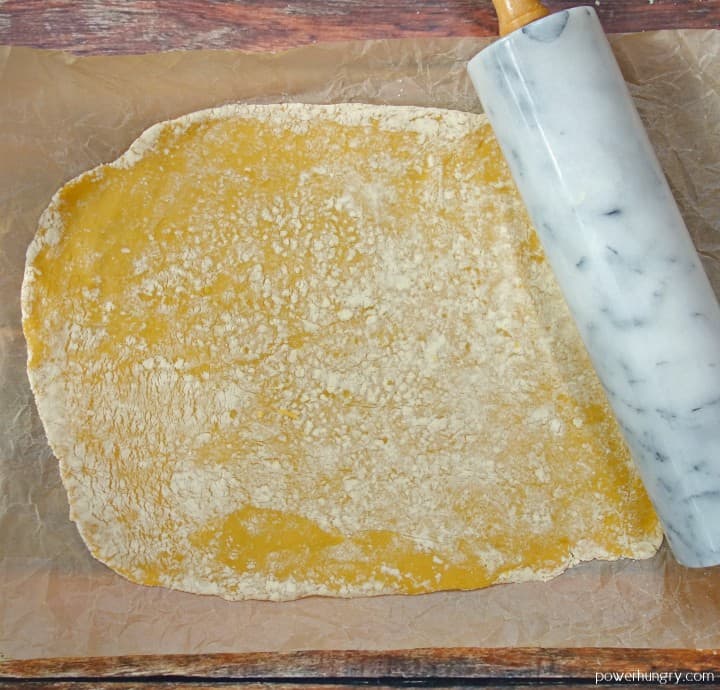 chickpea flour cracker doll rolled out with a marble rolling pin