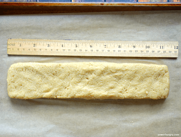 Vegan Almond Flour Biscotti dough on a baking sheet, shaped into an 11-inch log