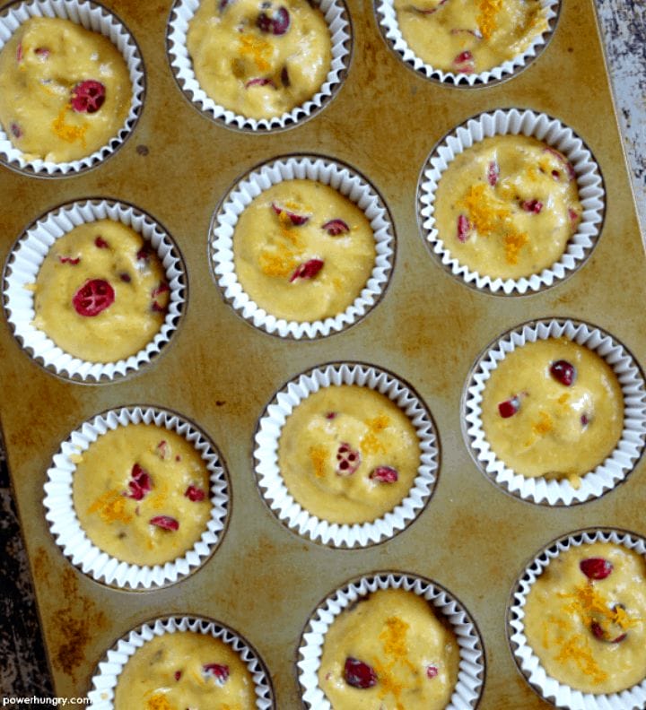 overhead shot of unbaked cranberry orange muffins in a muffin tin