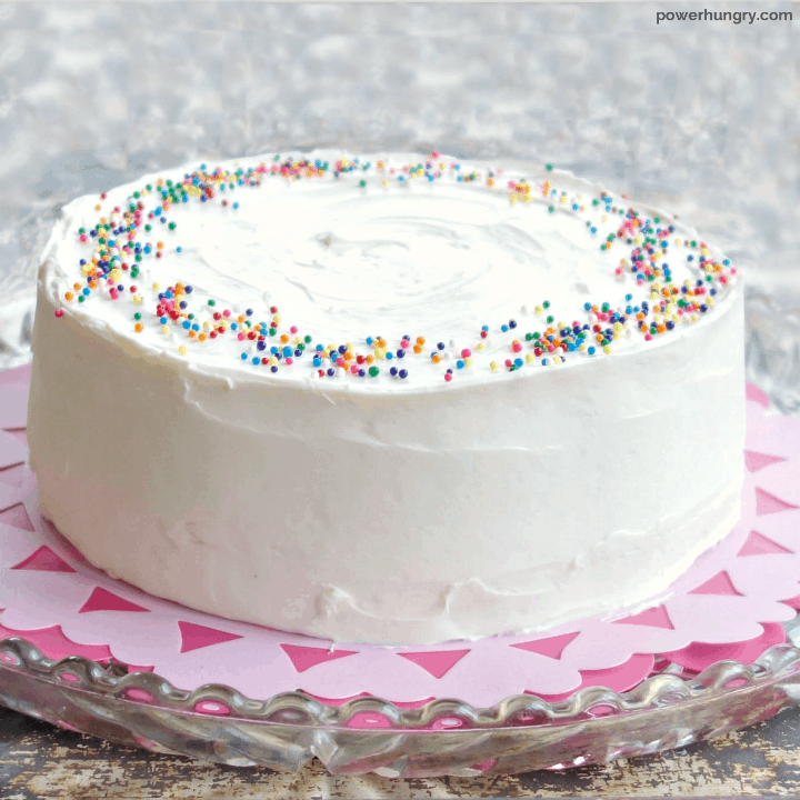 Vanilla layer cake that is vegan and grain free, frosted, with colorful sprinkles
