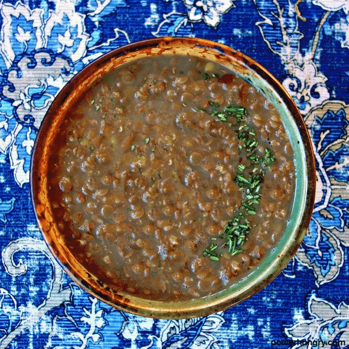 overhead shot of 3-ingredient lentil soup in a pottery bowl atop a blue napkin