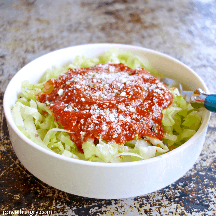 white bowl filled with caboodles, steamed cabbage noodles, and topped with marinara sauce