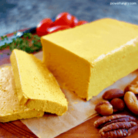 Block of vegan cheddar cheese on a cutting board