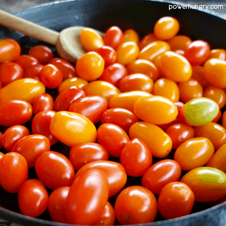 Cast iron skillet full of red and yellow cherry tomatoes
