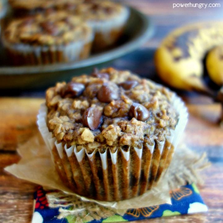 Peanut Butter Banana Baked Oatmeal Cup n floral napkin, with additional muffin cups and bananas in the background
