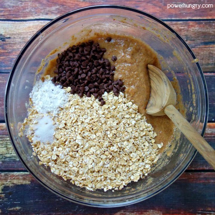 Dry ingredients added to glass bowl of wet ingredients for peanut butter banana baked oatmeal cups