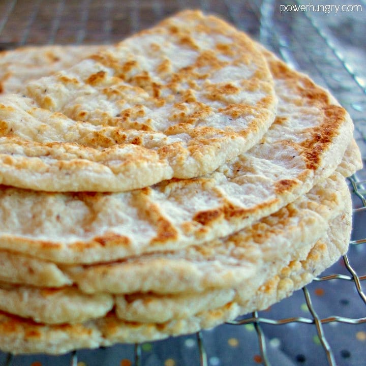 stack of coconut flour tortillas ona metal cooling rack, with the top tortilla folded