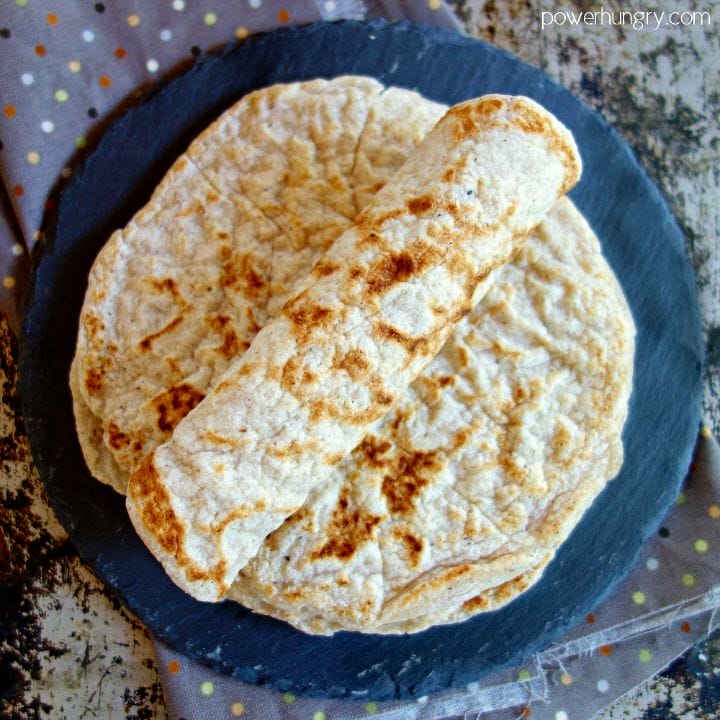 Rolled coconut flour tortilla on a stack of more tortillas
