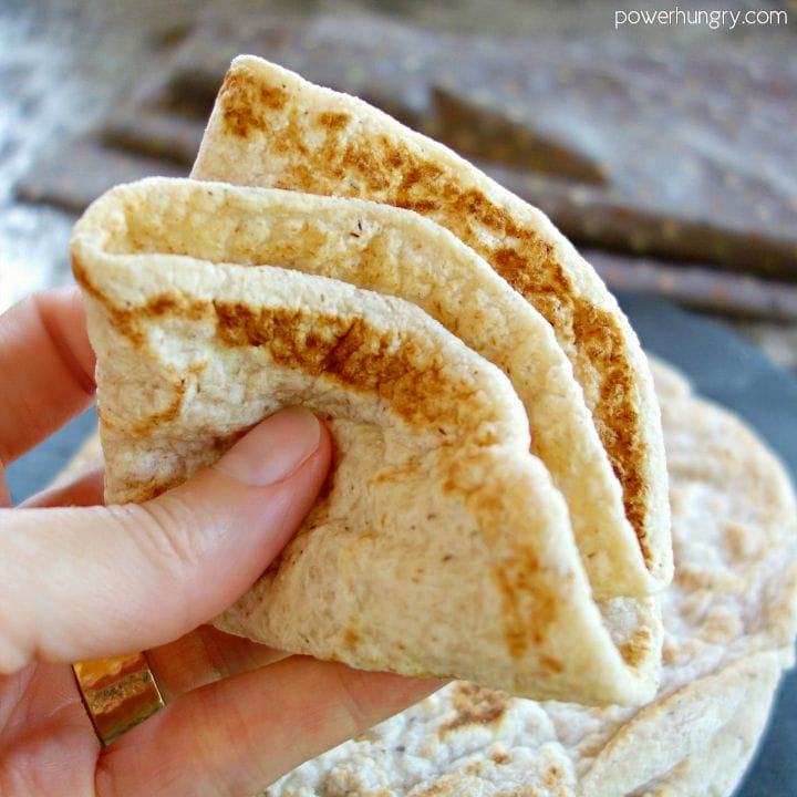 folded coconut flour tortilla being held in a woman's hand