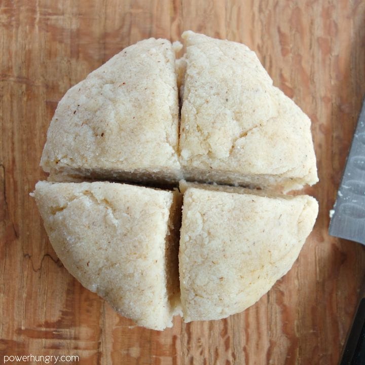 Dough for coconut flour tortillas on a wood cutting board, cut into 4 quadrants