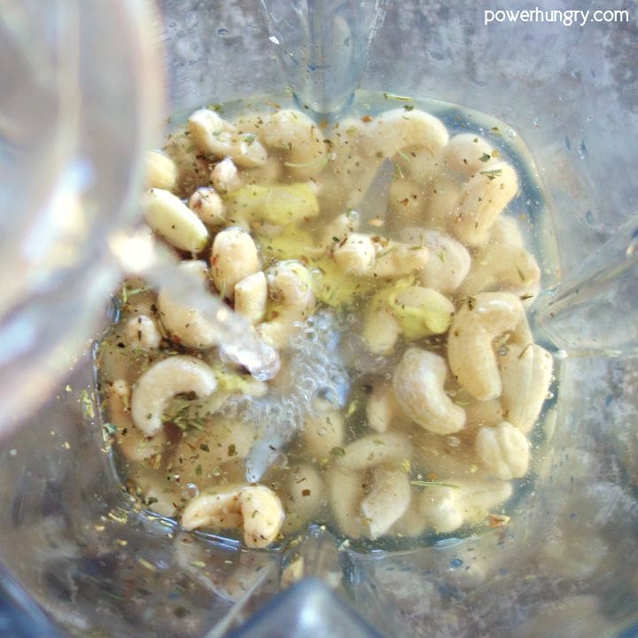 Blender filled with the ingredients for cashew salad dressing, before blending